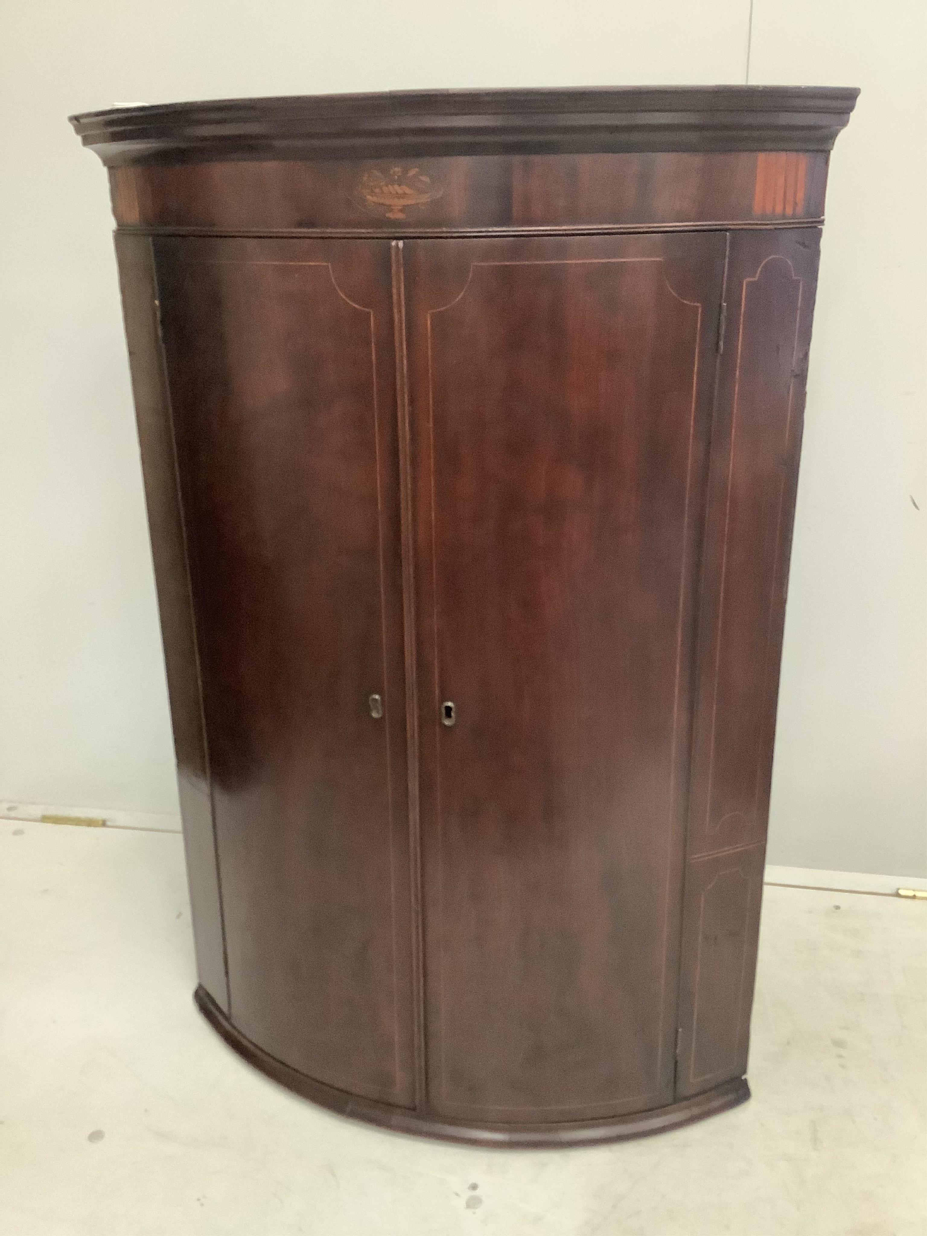 A George III inlaid mahogany bow front hanging corner cupboard, width 74cm, depth 50cm, height 107cm